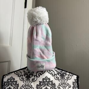 Hurley beanie in pastel camouflage colors with a white pom pom on top.
